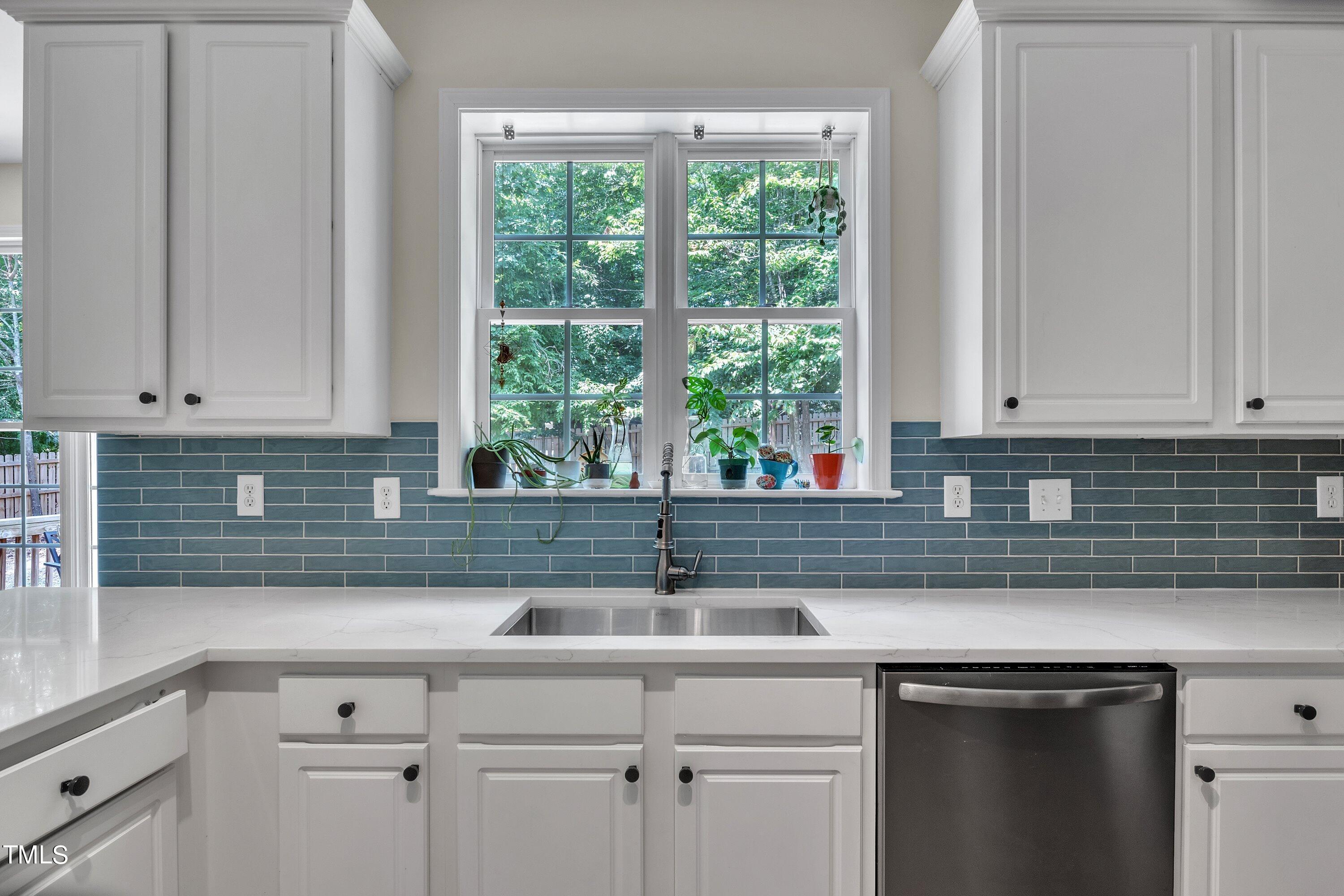 4702 Regency Drive Durham, NC 27713 - Photo 19 of 45 a sink with white cabinets and a window