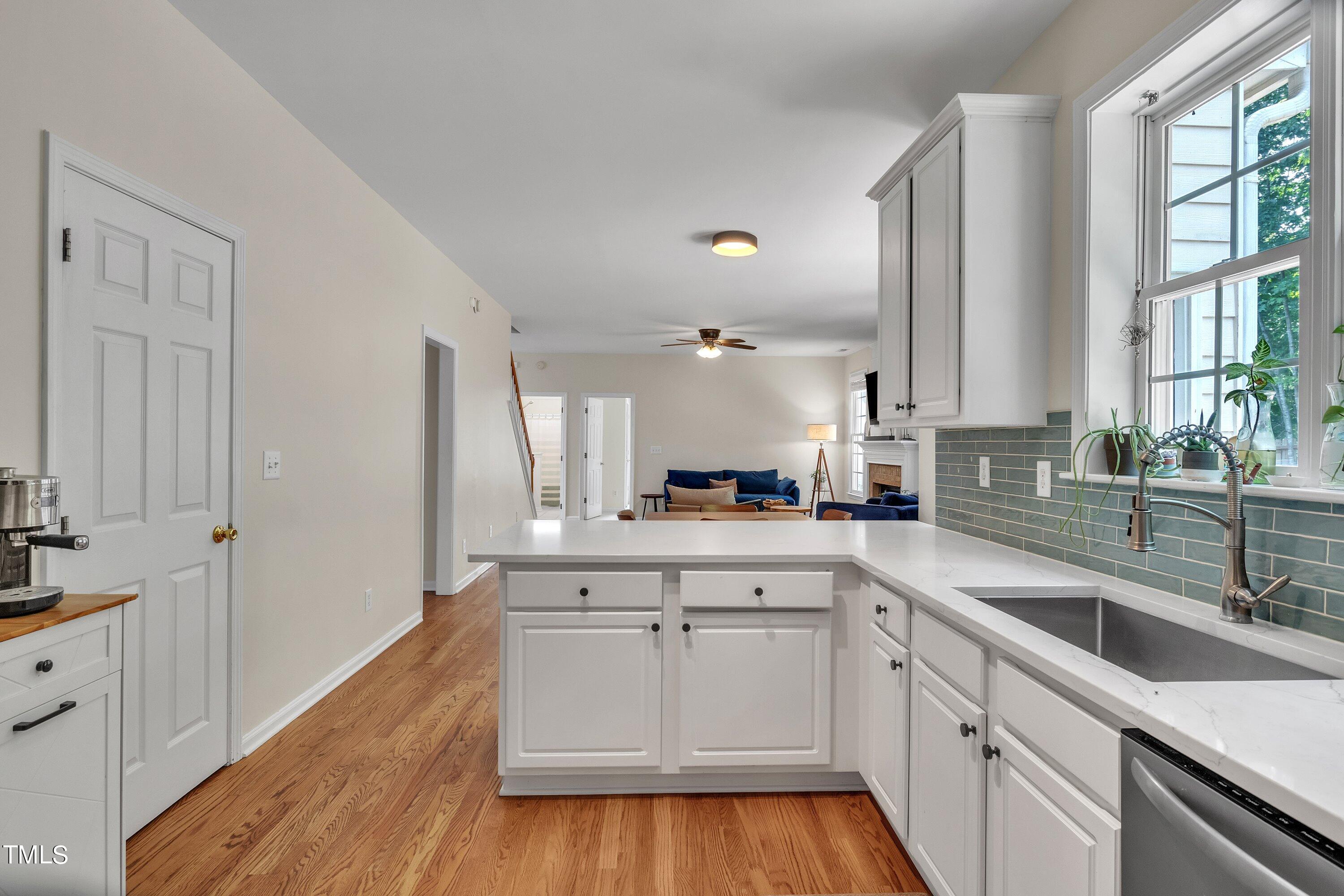 4702 Regency Drive Durham, NC 27713 - Photo 20 of 45 a kitchen with a sink dishwasher stove and white cabinets with wooden floor