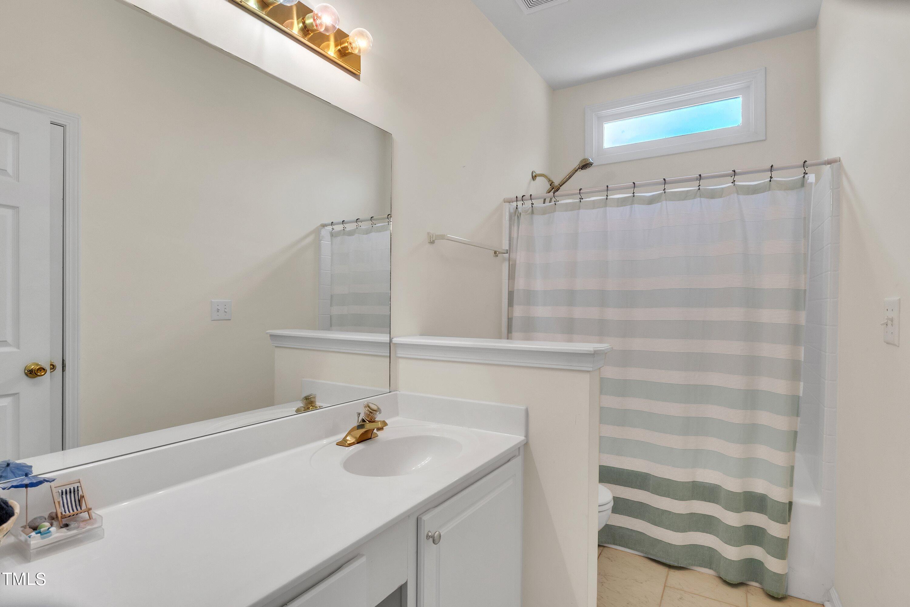 4702 Regency Drive Durham, NC 27713 - Photo 23 of 45 a bathroom with a sink and a mirror