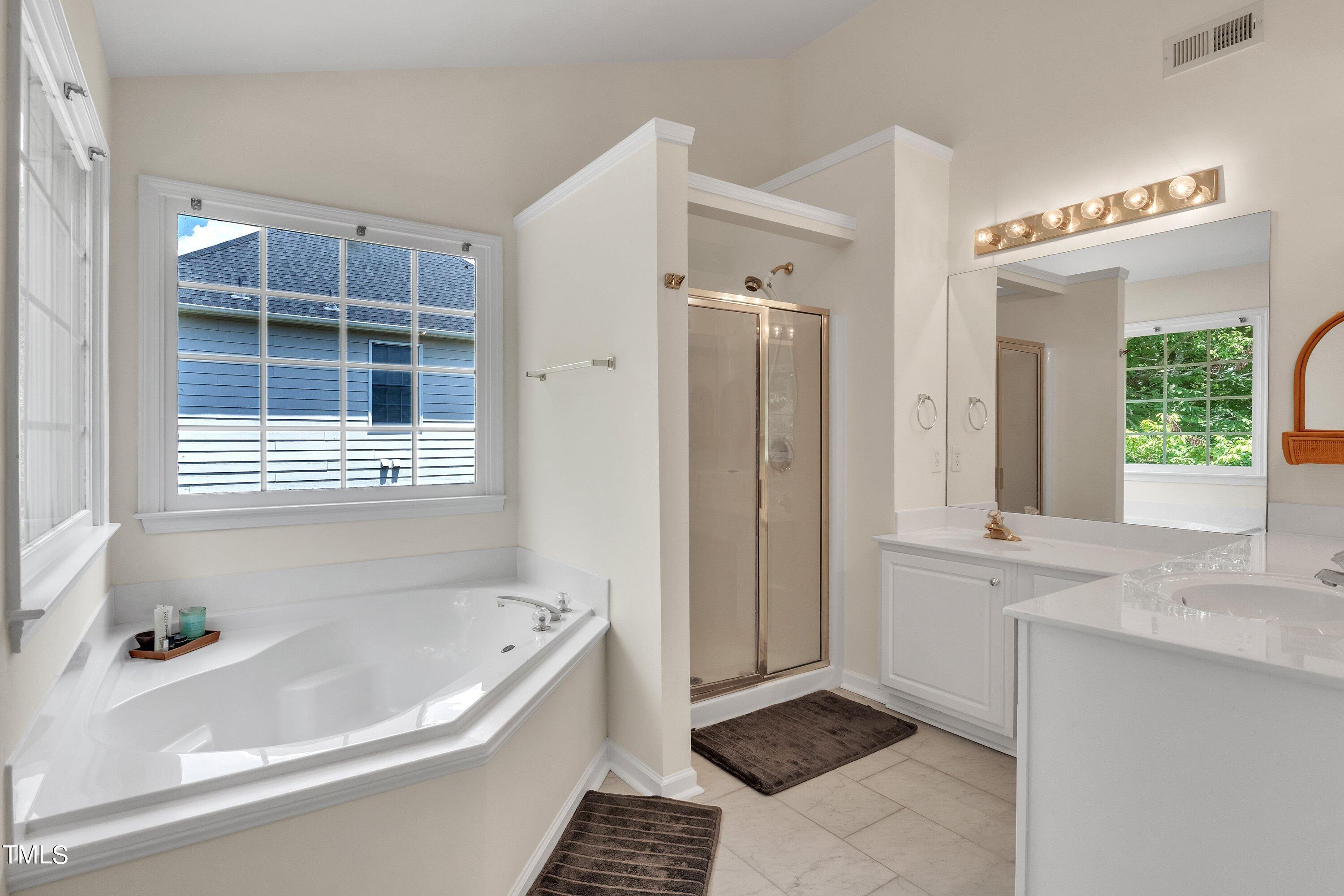 4702 Regency Drive Durham, NC 27713 - Photo 29 of 45 a bathroom with a bathtub a sink and a window