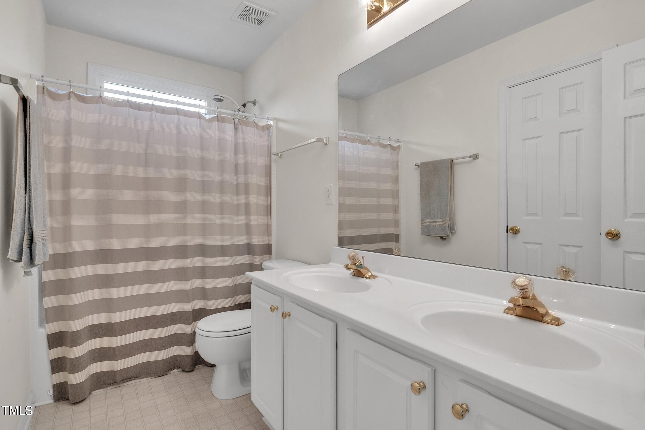 4702 Regency Drive Durham, NC 27713 - Photo 39 of 45 a bathroom with a sink toilet double vanity and shower