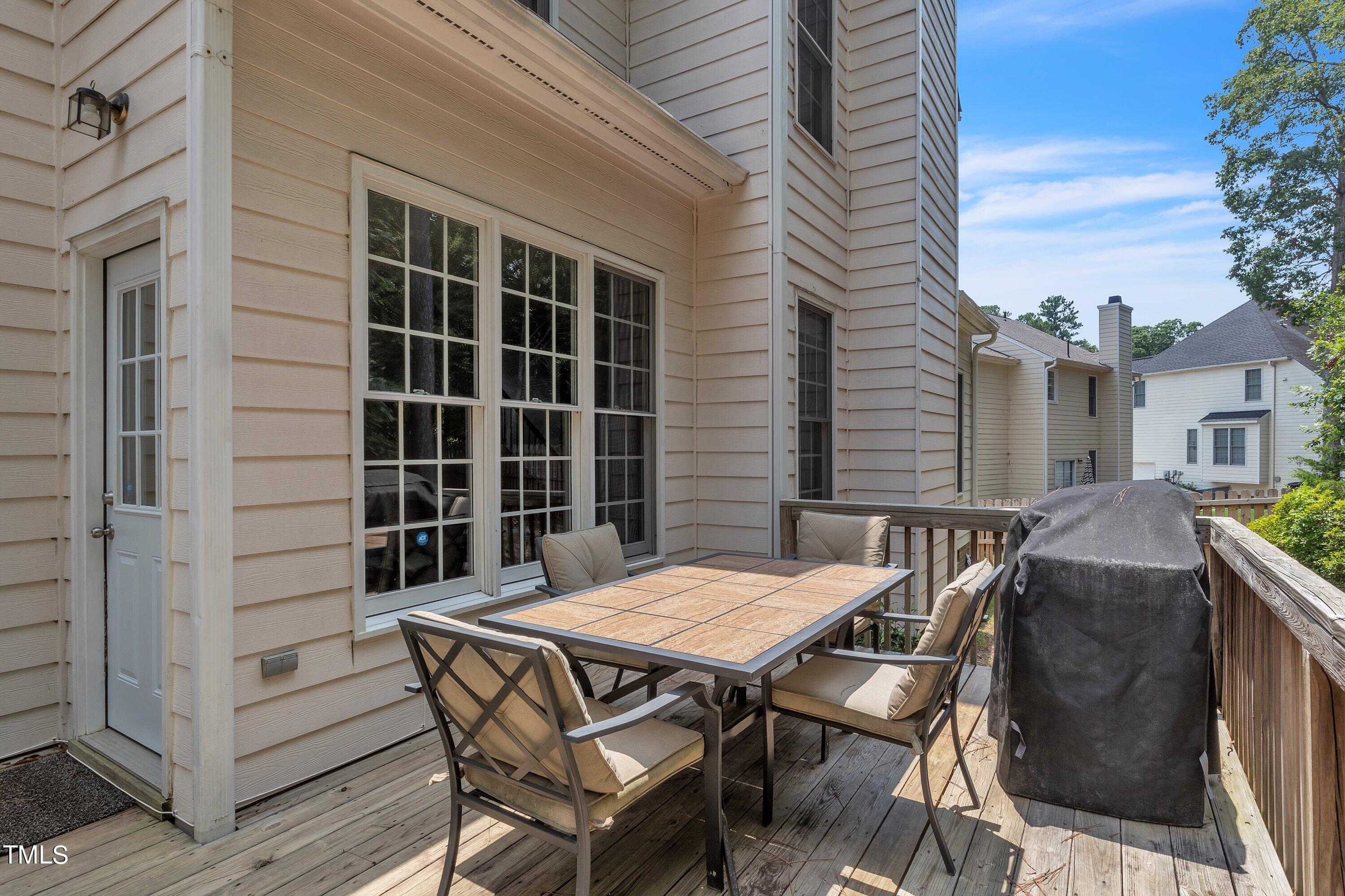4702 Regency Drive Durham, NC 27713 - Photo 42 of 45 a view of a patio with table and chairs with wooden floor and fence