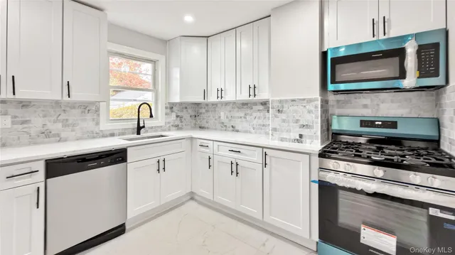 a kitchen with white cabinets and stainless steel appliances