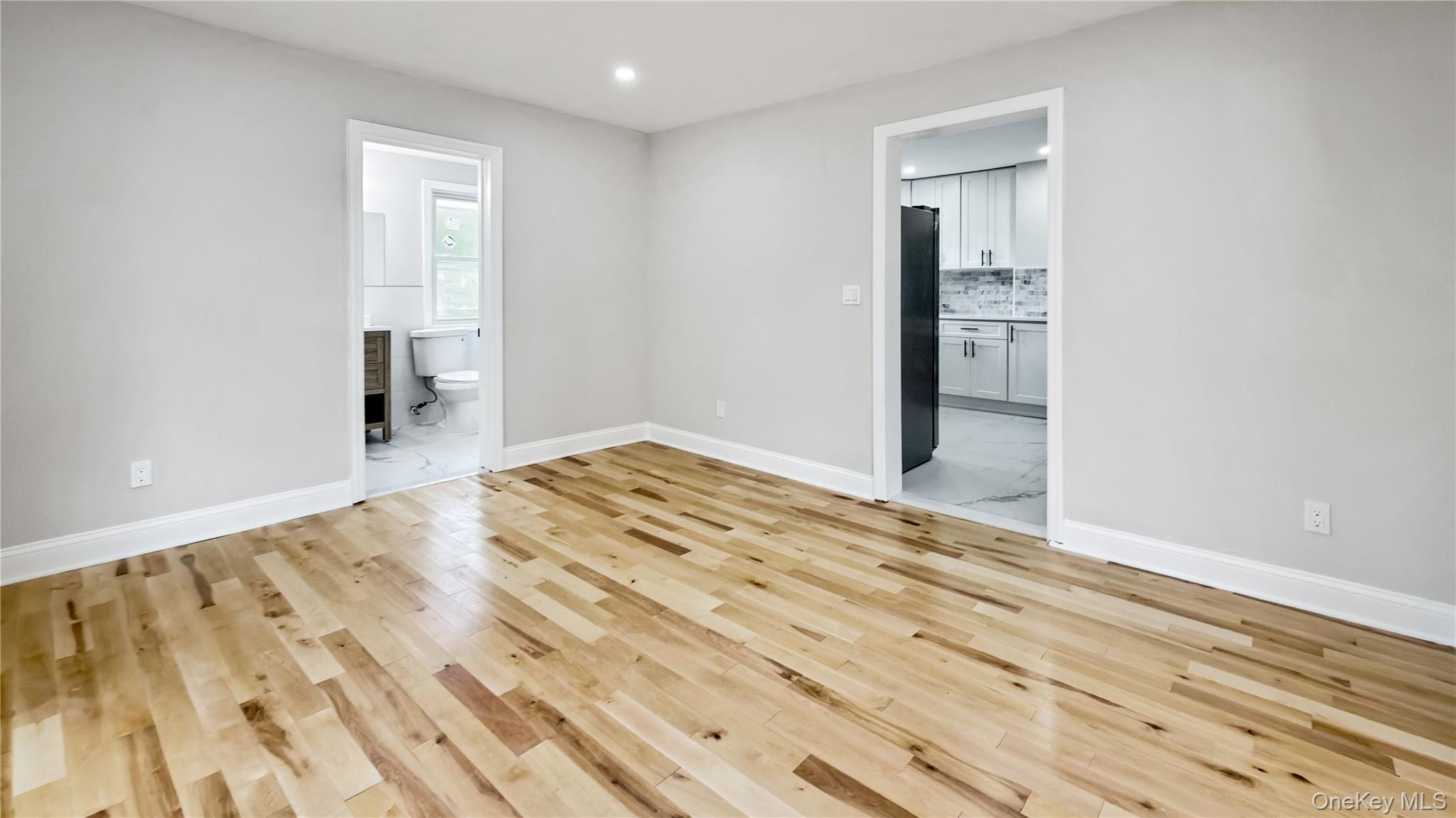64 South Montgomery Street Valley Stream, NY 11580 - Photo 22 of 47 Unfurnished bedroom with ensuite bath, light wood finished floors, recessed lighting, and freestanding refrigerator