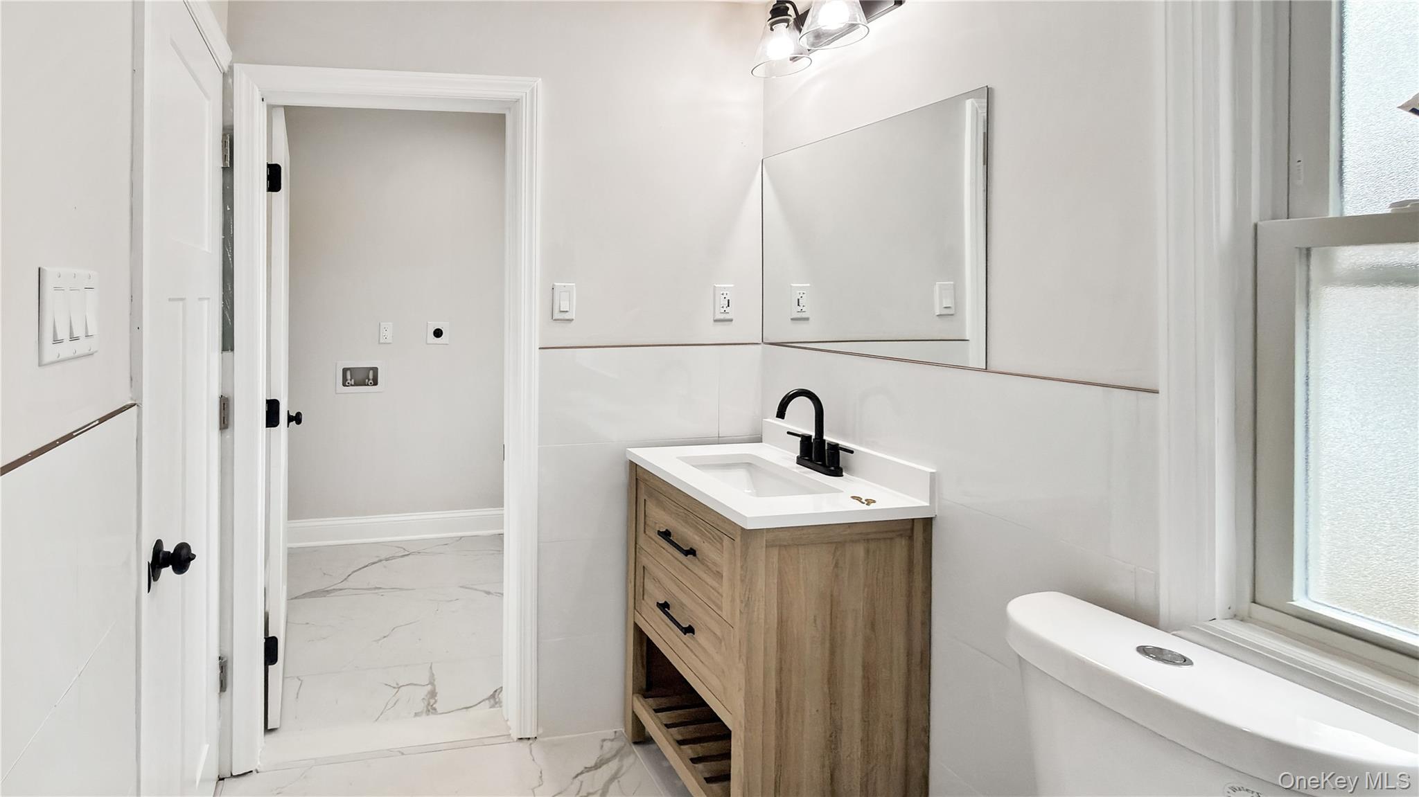 64 South Montgomery Street Valley Stream, NY 11580 - Photo 24 of 47 Half bathroom with light marble finish floors and vanity