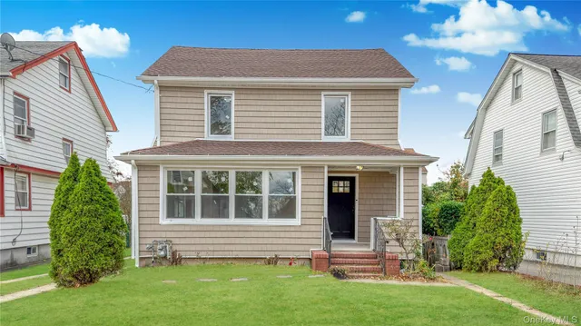 a front view of a house with a garden