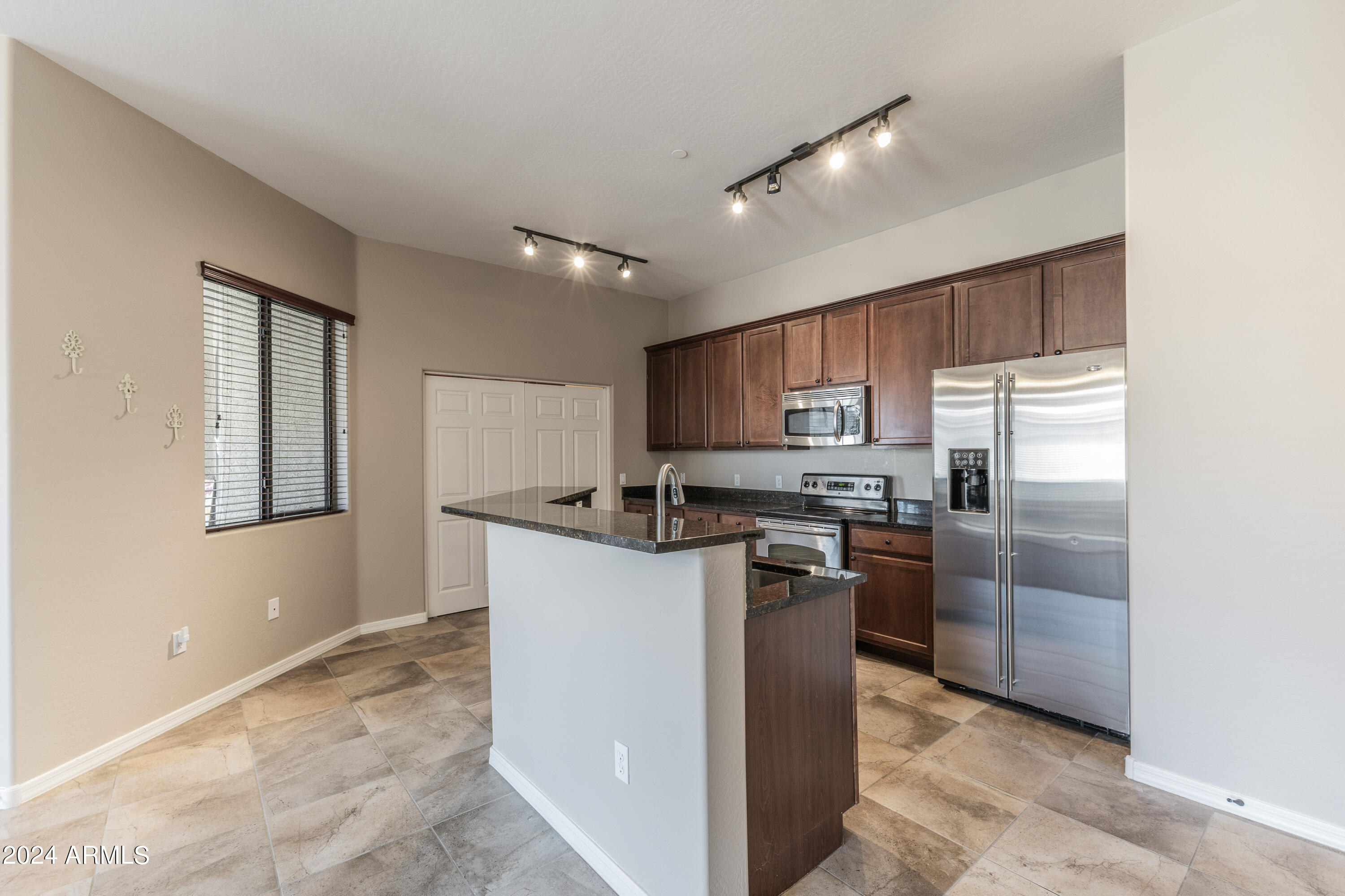 3330 South Gilbert Road, Unit 2010 Chandler, AZ 85286 - Photo 6 of 20 a kitchen with stainless steel appliances granite countertop a stove top oven a sink and a refrigerator