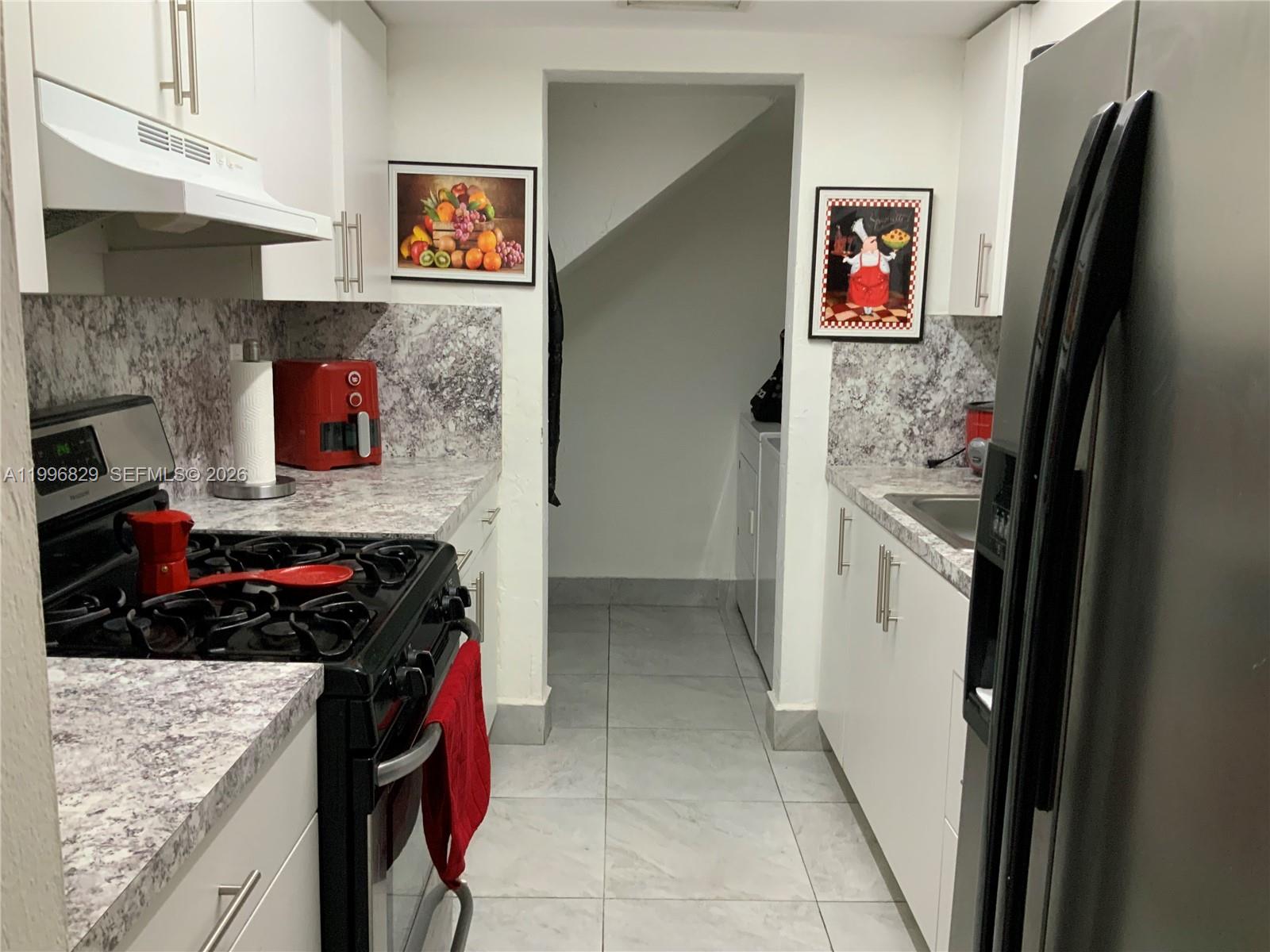 1300 West 53rd Street, Unit 35 Hialeah, FL 33012 - Photo 4 of 9 a kitchen with stainless steel appliances granite countertop a refrigerator and a stove