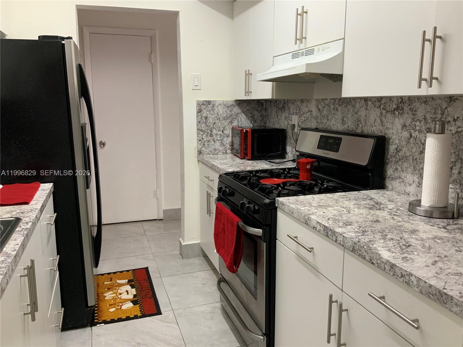 1300 West 53rd Street, Unit 35 Hialeah, FL 33012 - Photo 5 of 9 a kitchen with a stove and a refrigerator