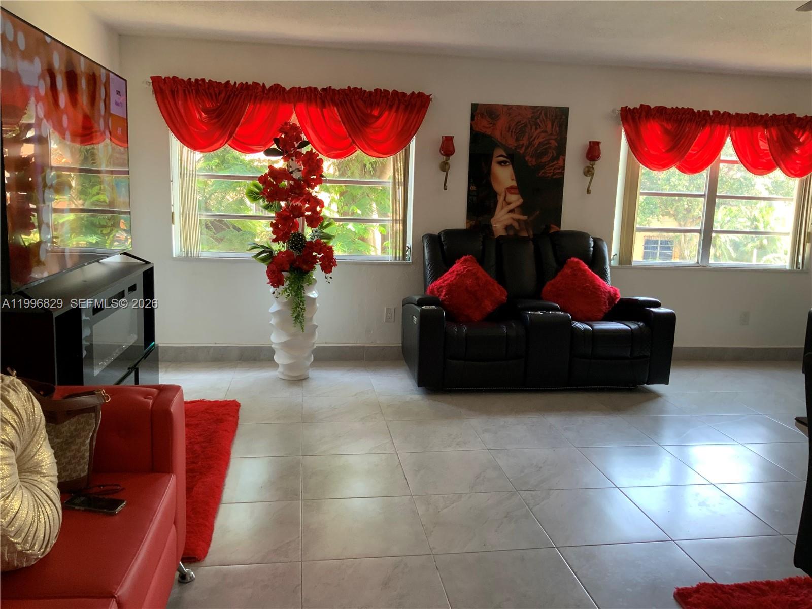 1300 West 53rd Street, Unit 35 Hialeah, FL 33012 - Photo 8 of 9 a living room with furniture a window and flat screen tv