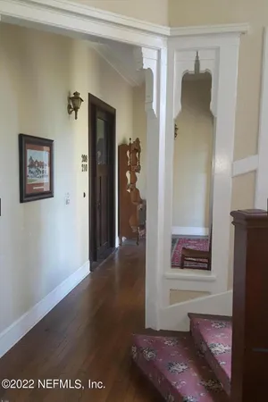 a view of a hallway with wooden floor and closet