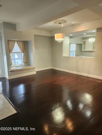 a view of empty room with wooden floor and fireplace