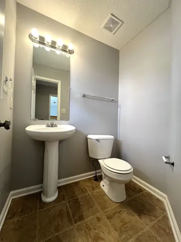 a bathroom with a sink toilet and a mirror