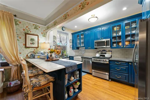 a open kitchen with stainless steel appliances granite countertop a stove refrigerator and a microwave