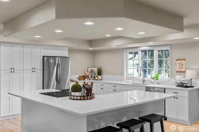 a kitchen with kitchen island a table chairs sink and wooden cabinets