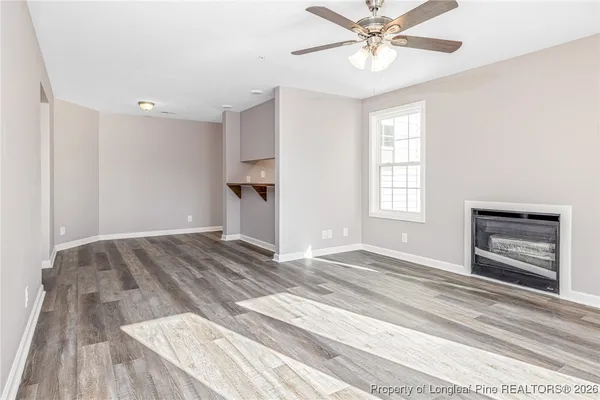 a view of an empty room with a window and a ceiling fan