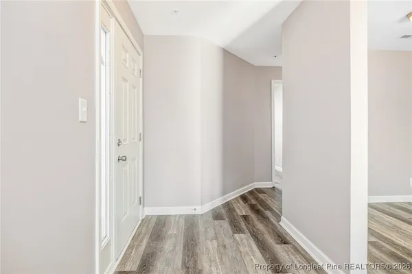 a view of room with walk in closet and wooden floor