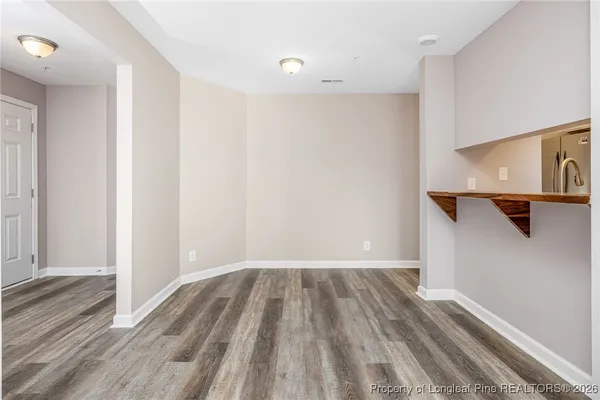 a view of a room with wooden floor and bench