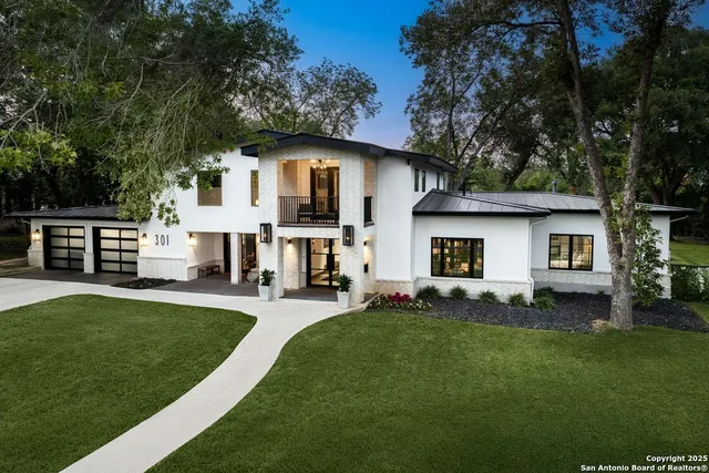 a front view of a house with a garden and trees