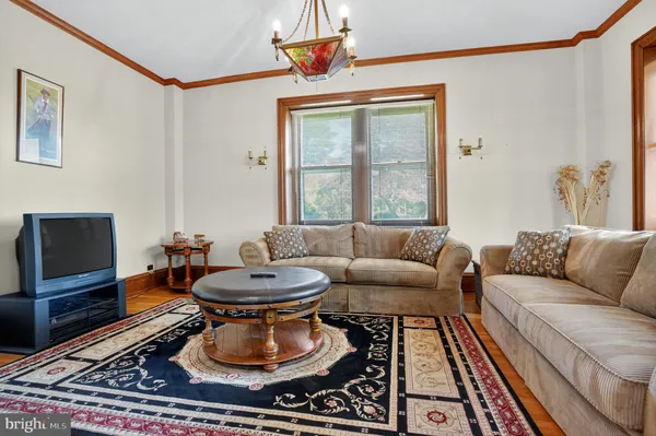 a living room with furniture a flat screen tv and a floor to ceiling window