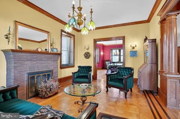 a living room with furniture a chandelier and a fireplace