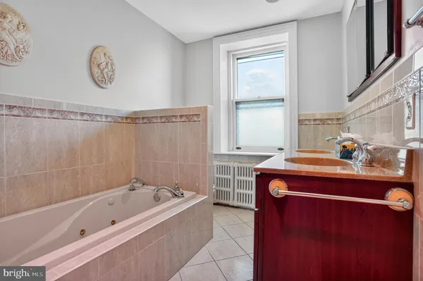 a bathroom with a tub sink and a window