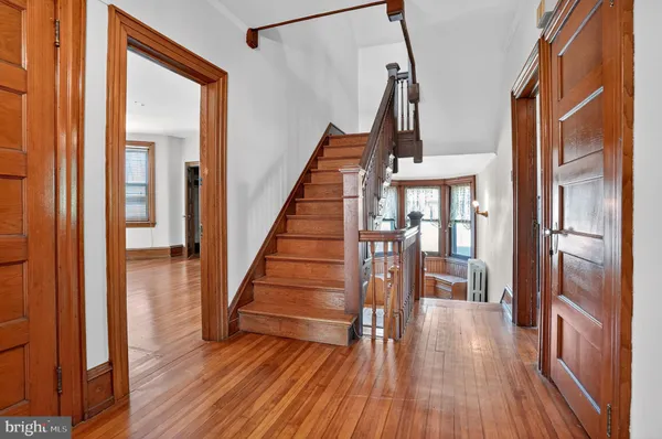 a view of entryway and hall with wooden floor