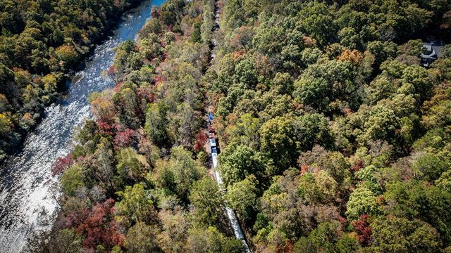 a view of a house with a lush green forest