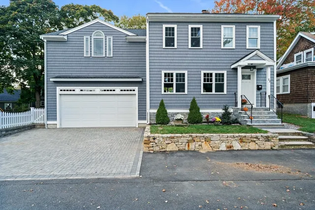 a front view of a house with a yard and a garage