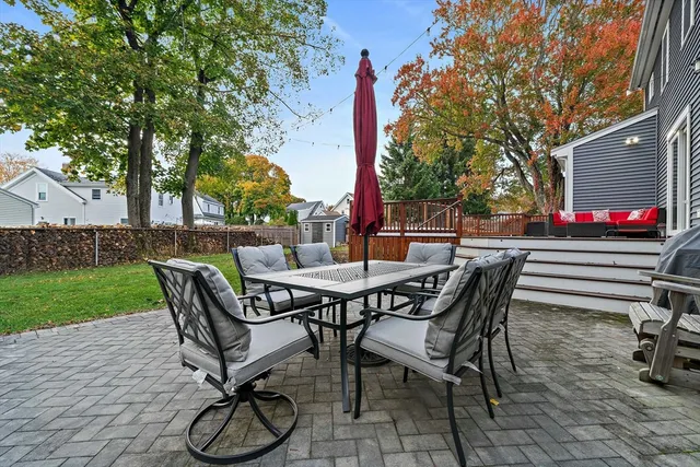 a view of a backyard with table and chairs with wooden floor and fence