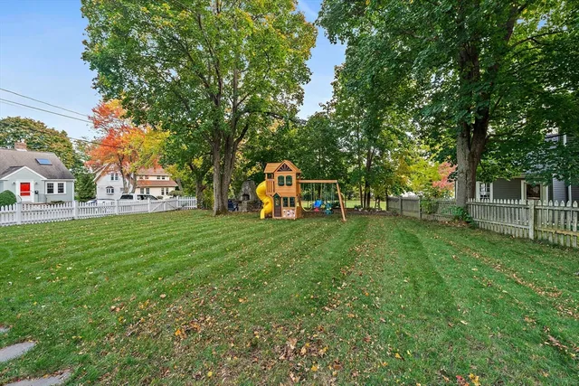 a view of a house with backyard and a tree