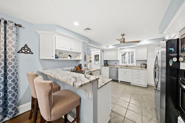 a living room with stainless steel appliances kitchen island granite countertop furniture and a refrigerator