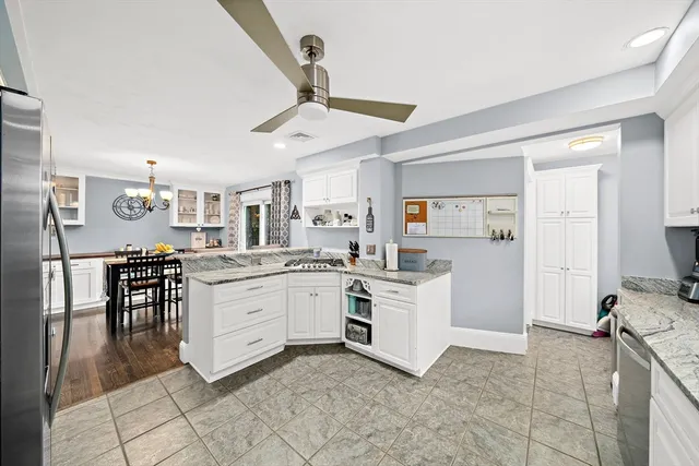 a kitchen with white cabinets and sink