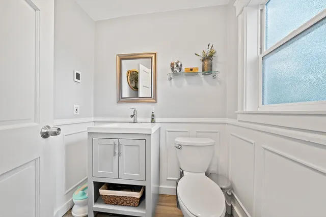 a bathroom with a toilet a sink and mirror