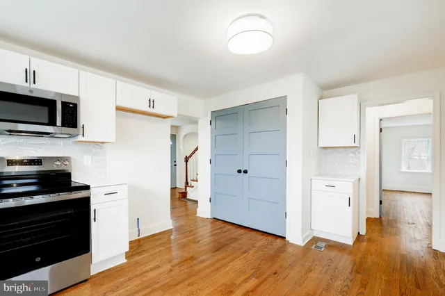 a view of a kitchen with wooden floor and electronic appliances