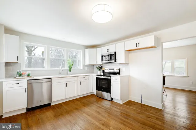 a kitchen with white cabinets and white appliances