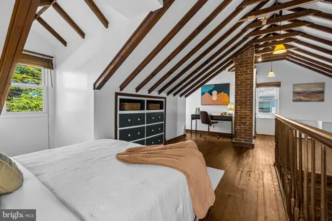 a bed sitting in a bedroom next to a window
