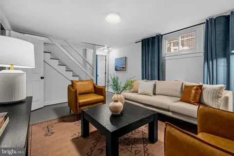 a living room with furniture potted plant and a window