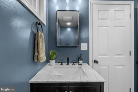 a bathroom with a granite countertop sink a toilet and mirror