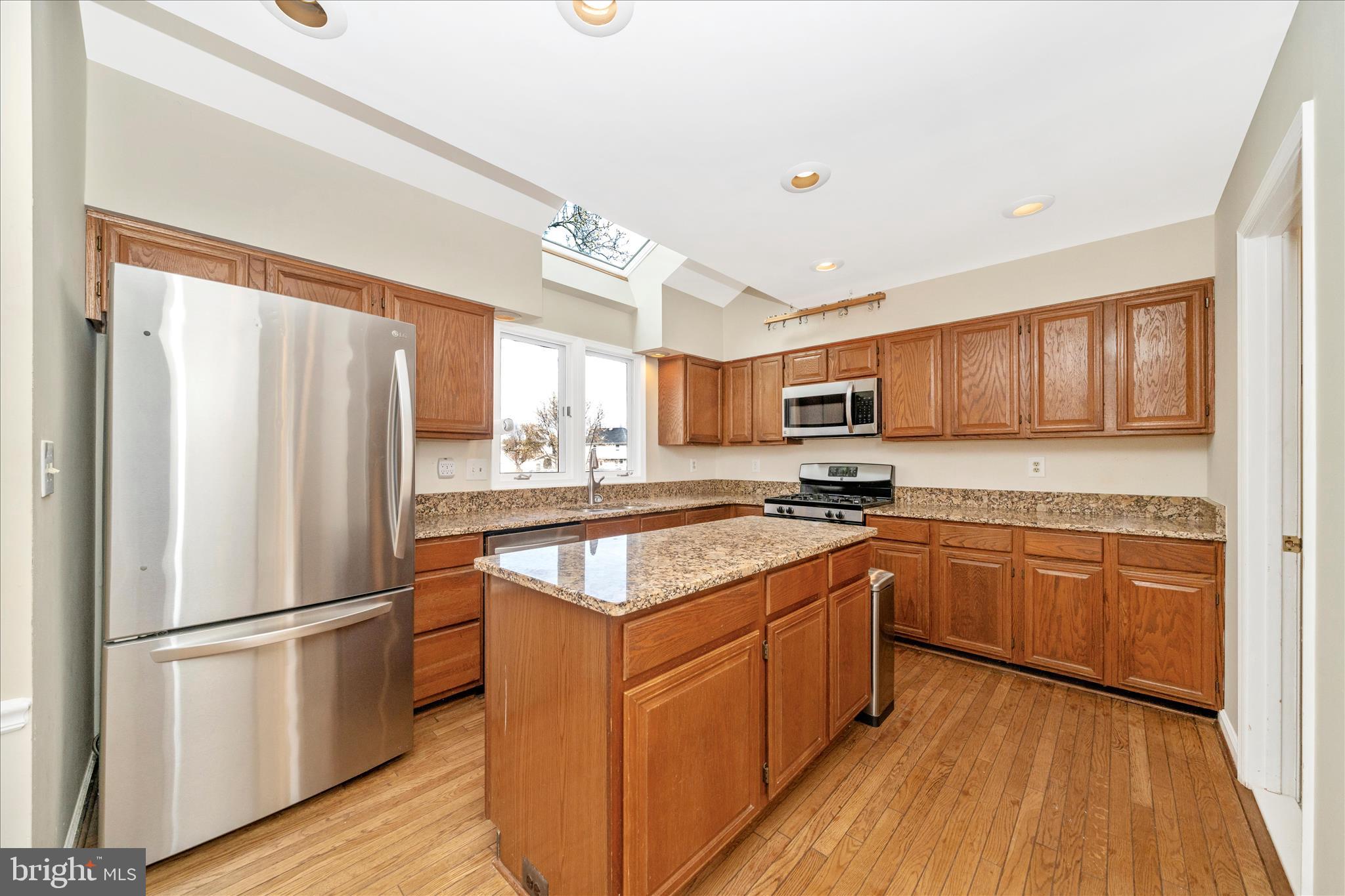 17004 Spates Hill Road Poolesville, MD 20837 - Photo 12 of 67 a kitchen with stainless steel appliances granite countertop a refrigerator a stove top oven a sink and dishwasher with wooden floor