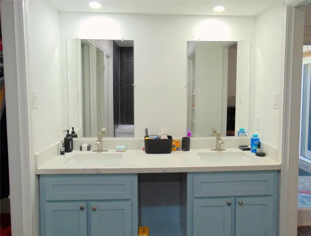 a bathroom with double sink and a mirror