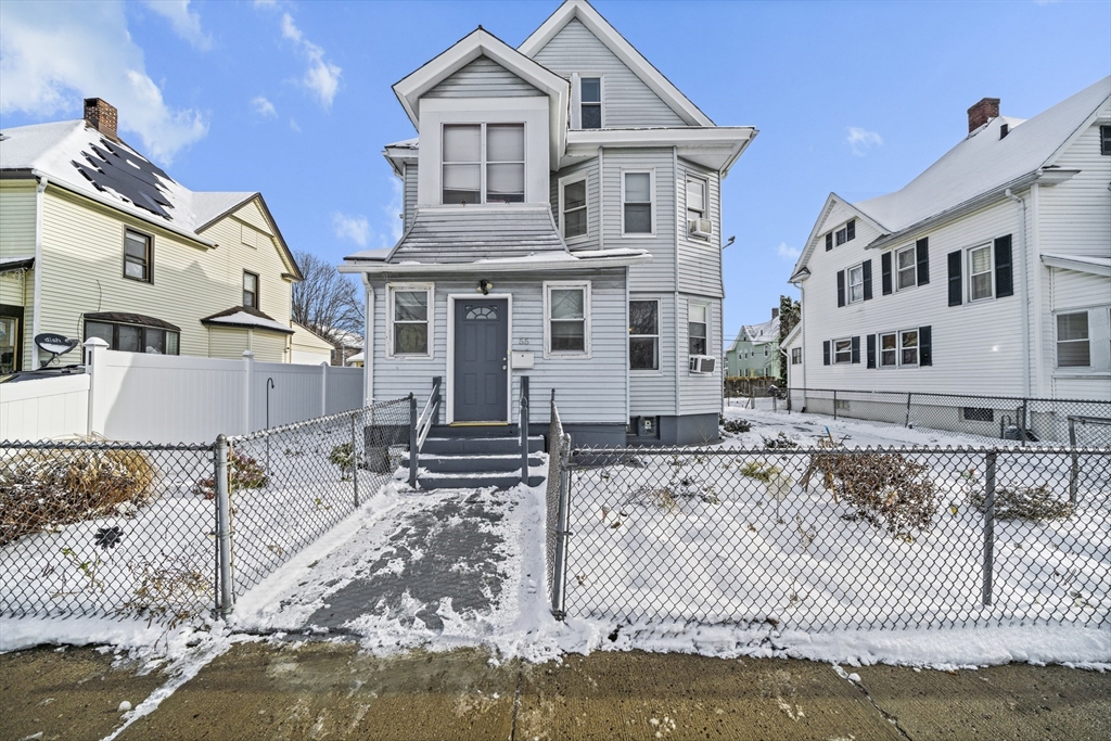 a view of a white house with wooden walls next to a road