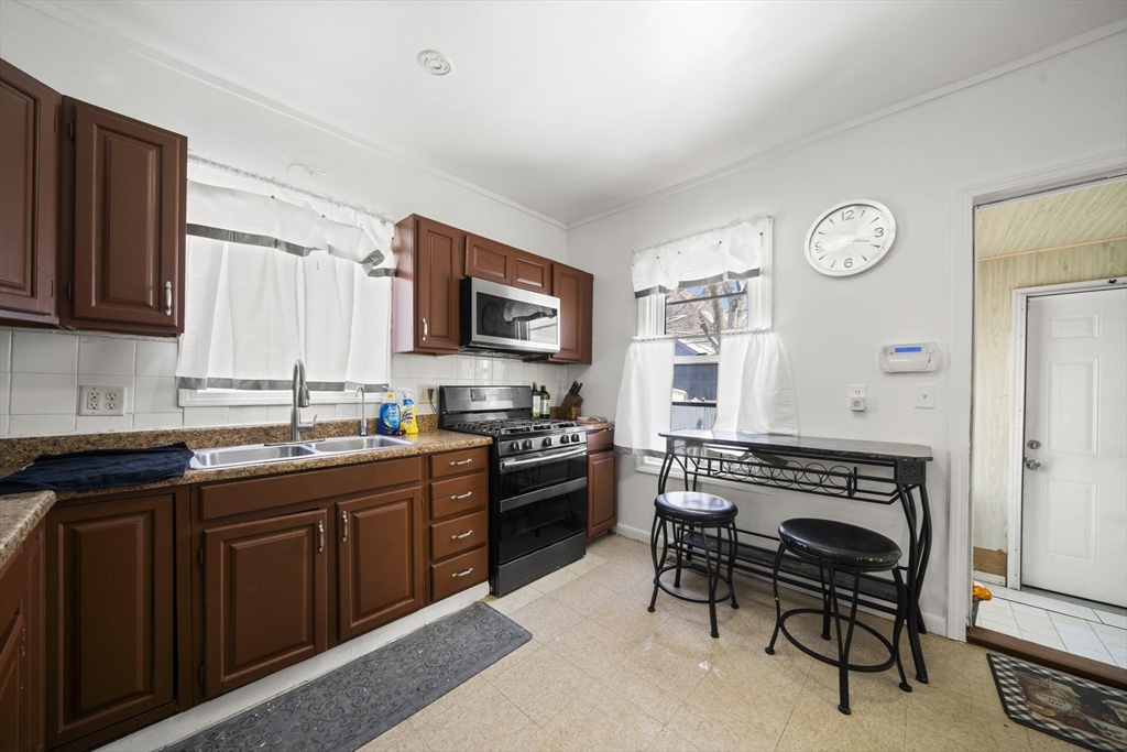 55 Malden Street Springfield, MA 01108 - Photo 11 of 40 a kitchen with granite countertop a stove top oven a sink dishwasher and wooden cabinets