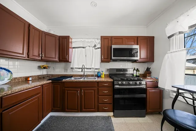 a kitchen with stainless steel appliances a stove a sink a microwave and wooden cabinets