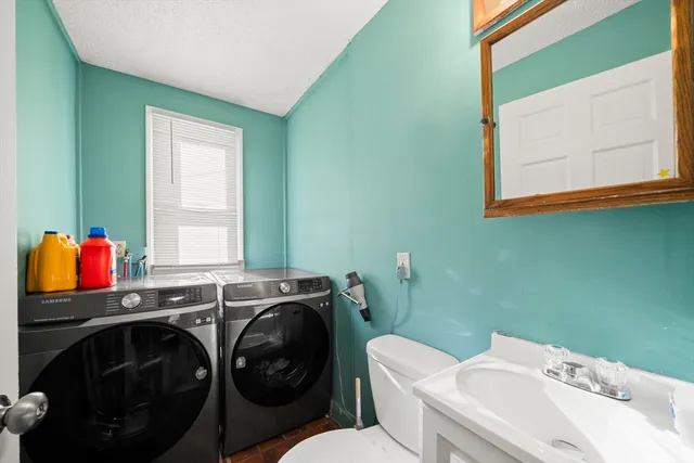 a bathroom with a sink a toilet and a window