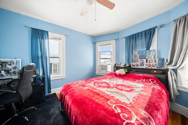 a bedroom with a bed and dresser with window