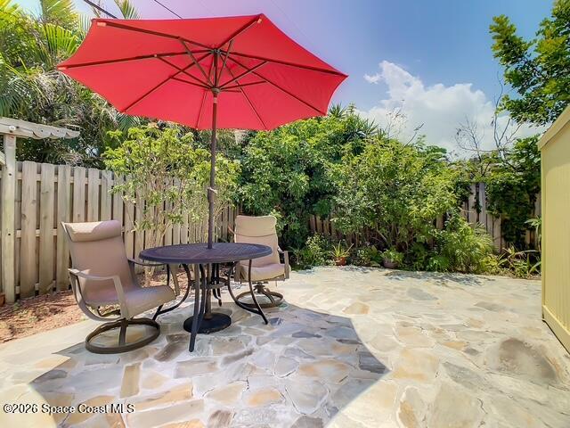 205 Rita Boulevard Melbourne Beach, FL 32951 - Photo 15 of 19 a view of a patio with table and chairs under an umbrella