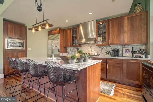 a kitchen with a dining table chairs cabinets and stainless steel appliances