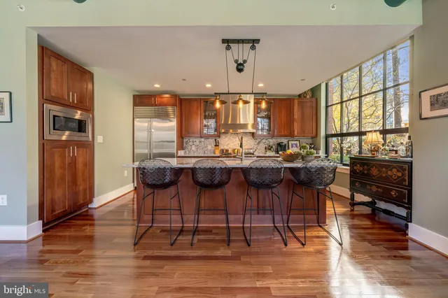 a kitchen with stainless steel appliances granite countertop sink stove and wooden cabinets