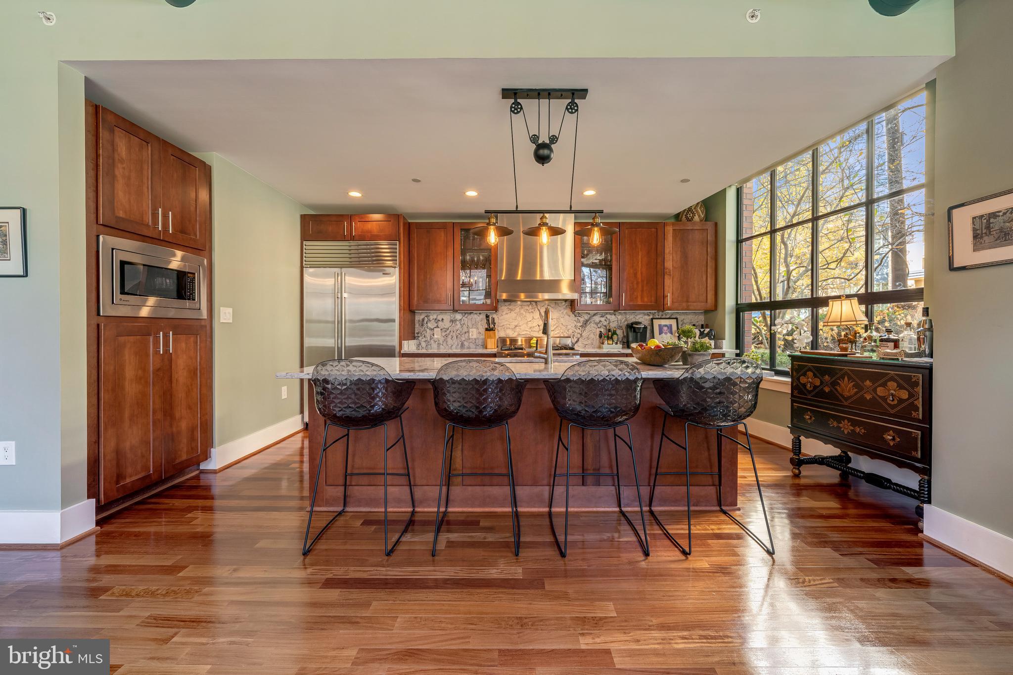 1600 Clarendon Boulevard, Unit W108 Arlington, VA 22209 - Photo 19 of 50 a kitchen with a dining table chairs cabinets and stainless steel appliances